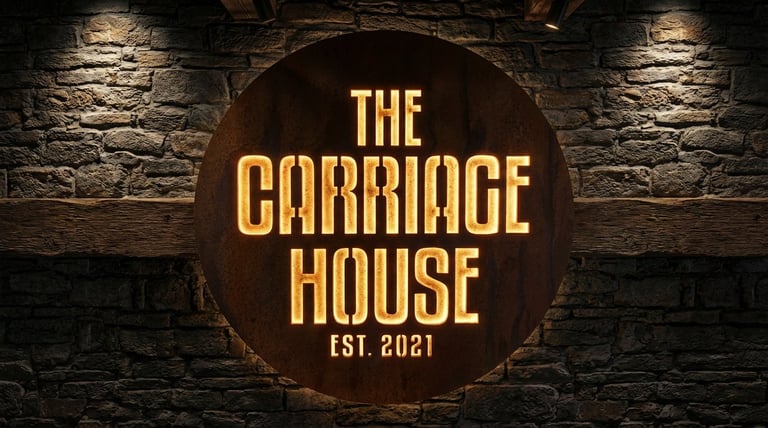 The Carriage House Est. 2021 gold lettering on circular sign mounted on stone wall